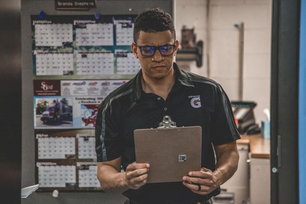 A man holding a checkboard getting ready to do a gemba walk